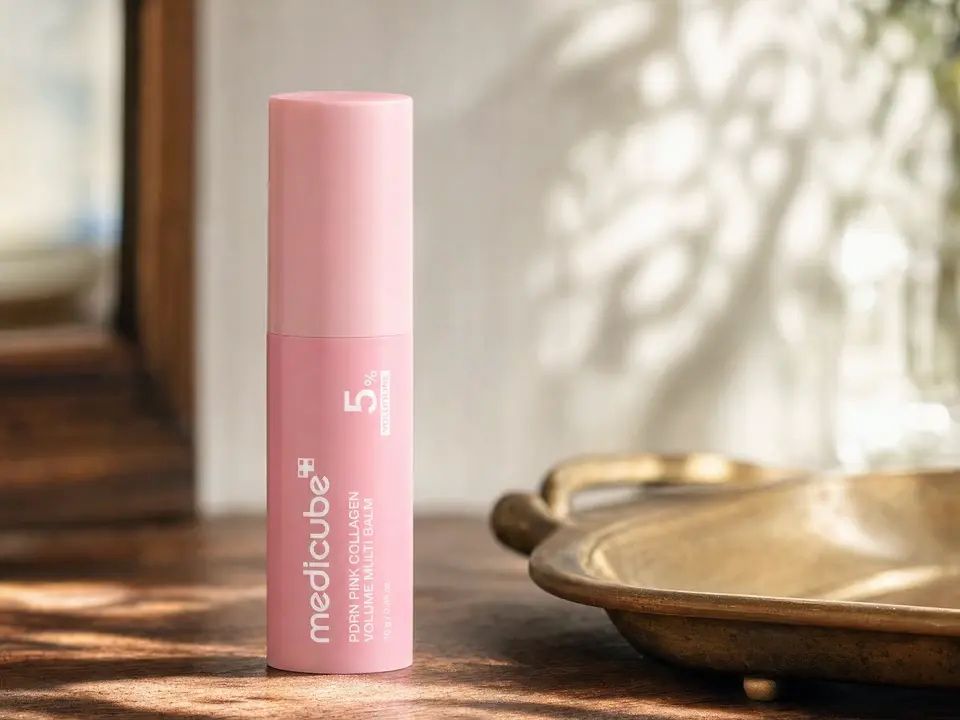 The medicube balm stick on a wooden windowsill in slowly shifting dappled light